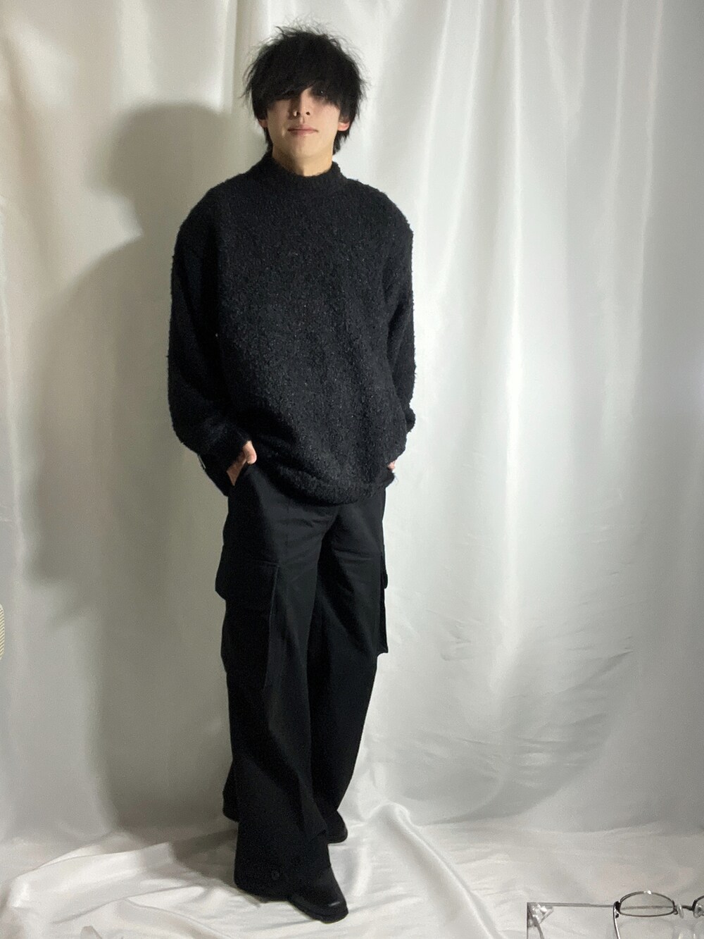 ブラック系のニット/セーター、ブラック系のカーゴパンツ、ブラック系のブーツを着用したメンズの秋コーディネートの2枚目の写真