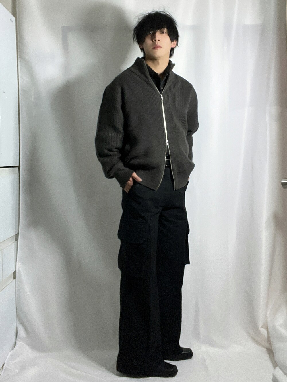 ブラック系のカーゴパンツ、グレー系のニット/セーター、ブラック系のシャツ/ブラウスを着用したメンズの秋コーディネートの4枚目の写真