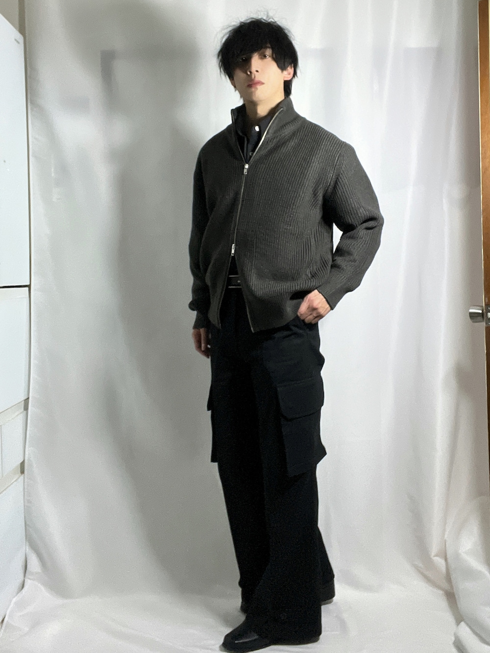 ブラック系のカーゴパンツ、グレー系のニット/セーター、ブラック系のシャツ/ブラウスを着用したメンズの秋コーディネートの3枚目の写真