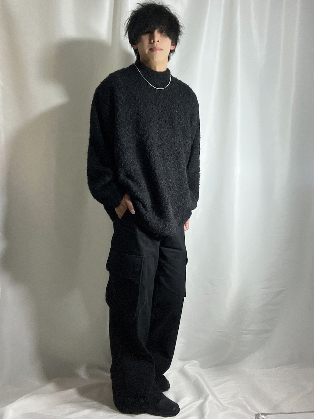 ブラック系のニット/セーター、ブラック系のカーゴパンツ、ブラック系のブーツを着用したメンズの秋コーディネートの3枚目の写真