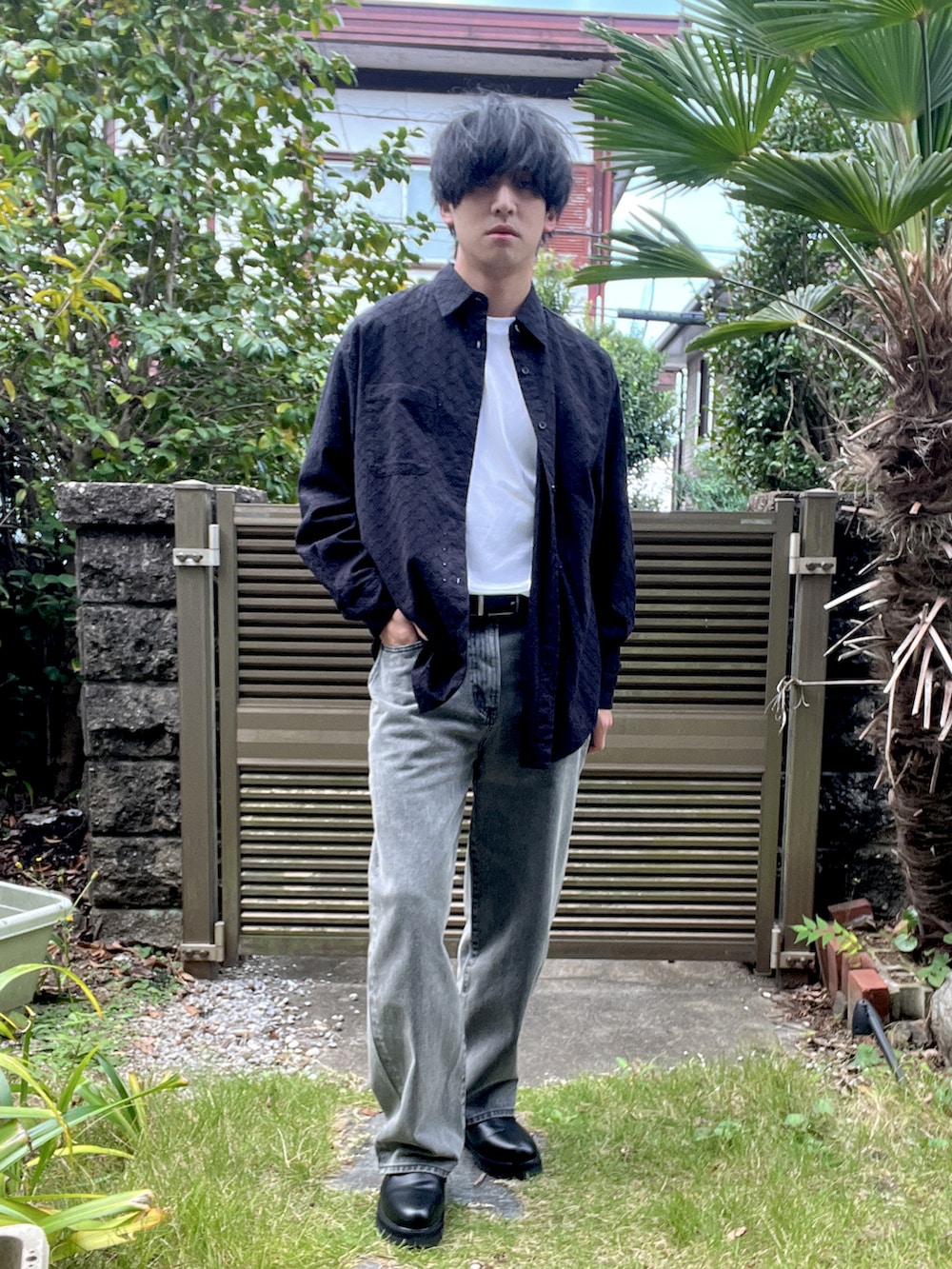 ブラック系のデニムパンツ、ブラック系のドレスシューズ、ホワイト系のTシャツ/カットソーを着用したメンズの秋コーディネートの2枚目の写真