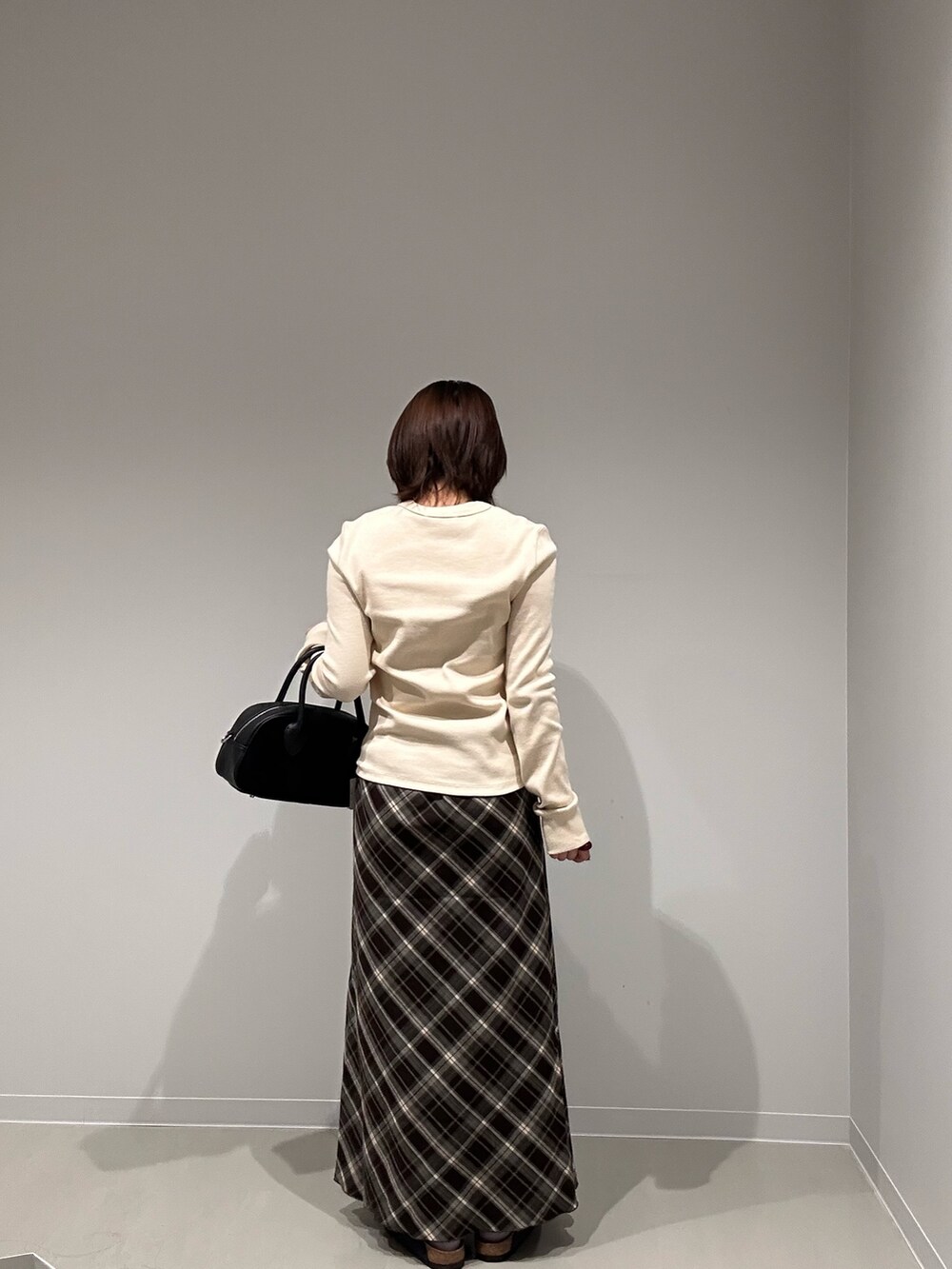 ホワイト系のTシャツ/カットソー、ブラウン系のスカート、ブラウン系のショルダーバッグを着用したレディースの秋コーディネートの4枚目の写真