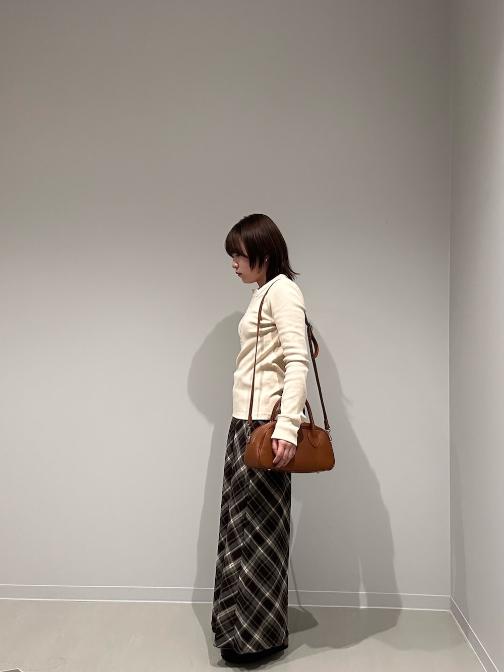 ホワイト系のTシャツ/カットソー、ブラウン系のスカート、ブラウン系のショルダーバッグを着用したレディースの秋コーディネートの3枚目の写真