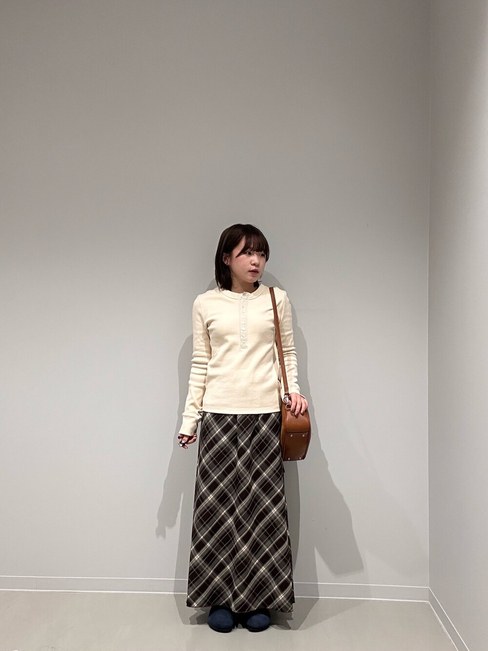 ホワイト系のTシャツ/カットソー、ブラウン系のスカート、ブラウン系のショルダーバッグを着用したレディースの秋コーディネートの2枚目の写真