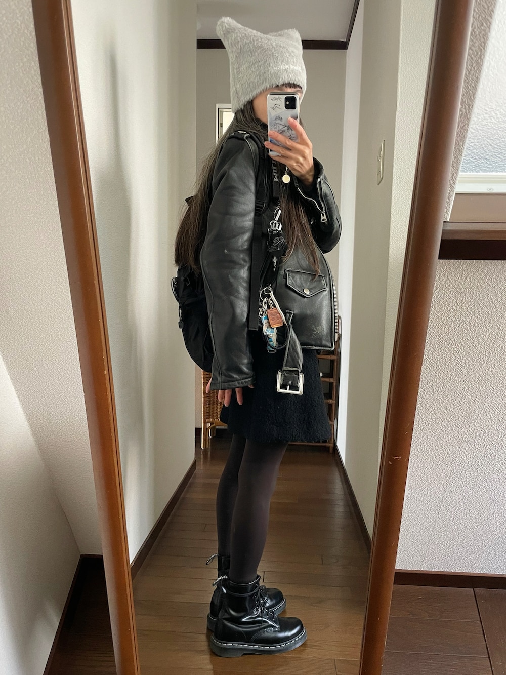 ブラック系のブーツ、ブラック系のスカート、ブラック系のライダースジャケットを着用したレディースの秋コーディネートの2枚目の写真