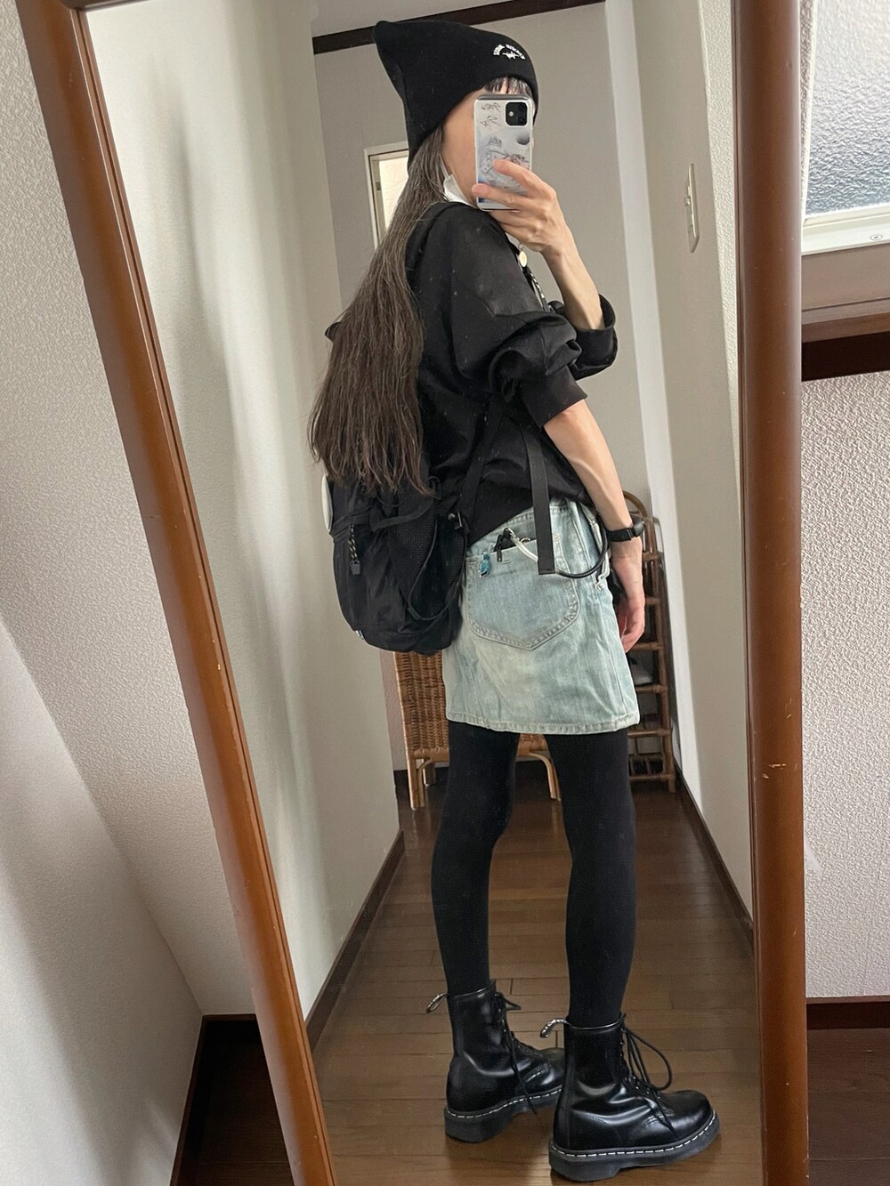 ブラック系のブーツ、ブラック系のブルゾン、ブルー系のデニムスカートを着用したレディースの秋コーディネートの2枚目の写真