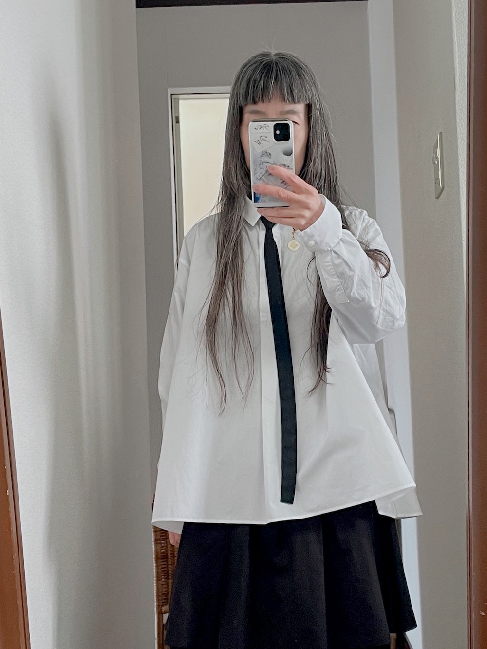 ブラック系のブーツ、ブラック系のバックパック/リュック、ブラック系のスカートを着用したレディースの春コーディネートの2枚目の写真