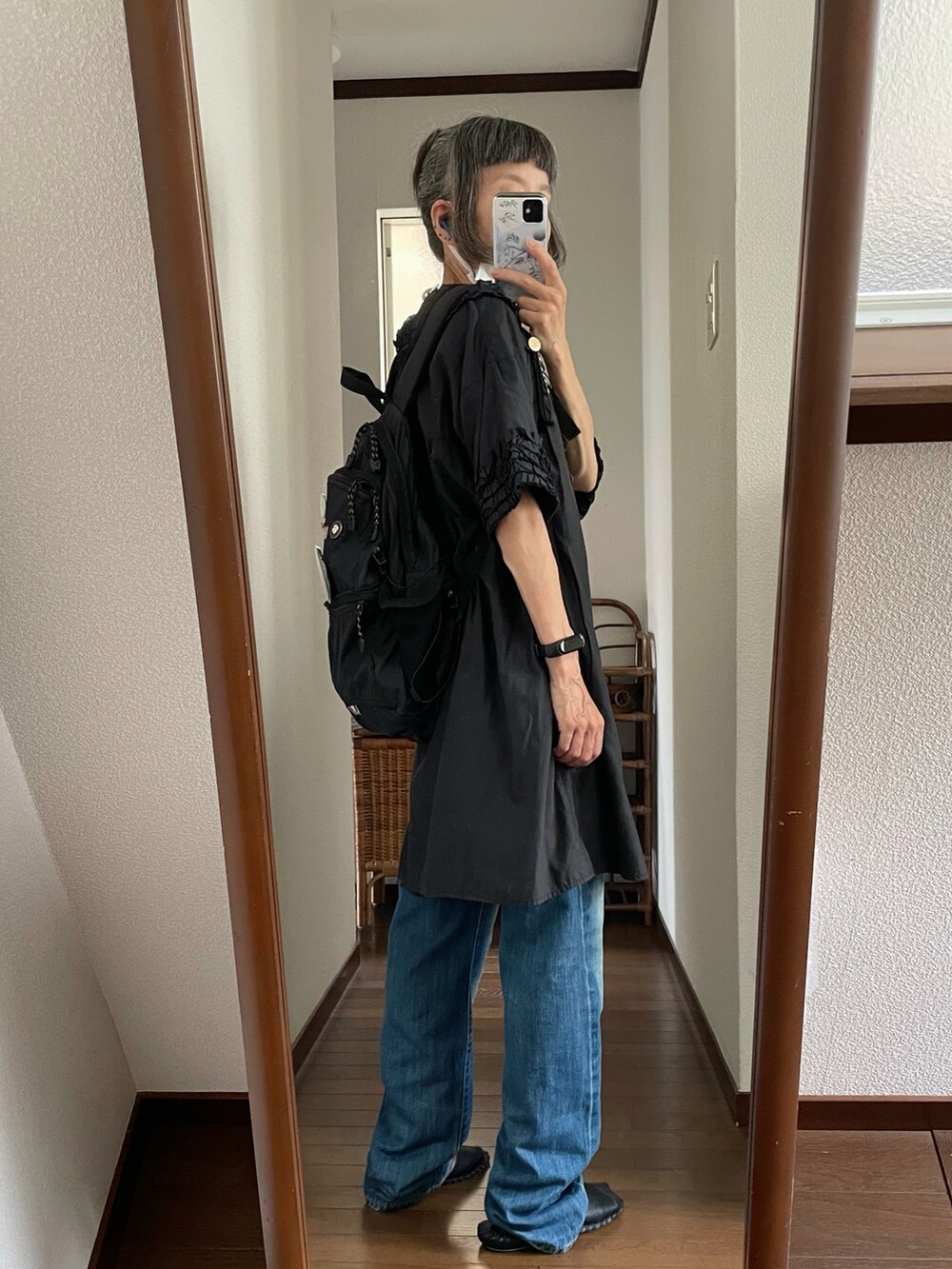 ブルー系のデニムパンツ、ブラック系のチュニックを着用したレディースの秋コーディネートの2枚目の写真