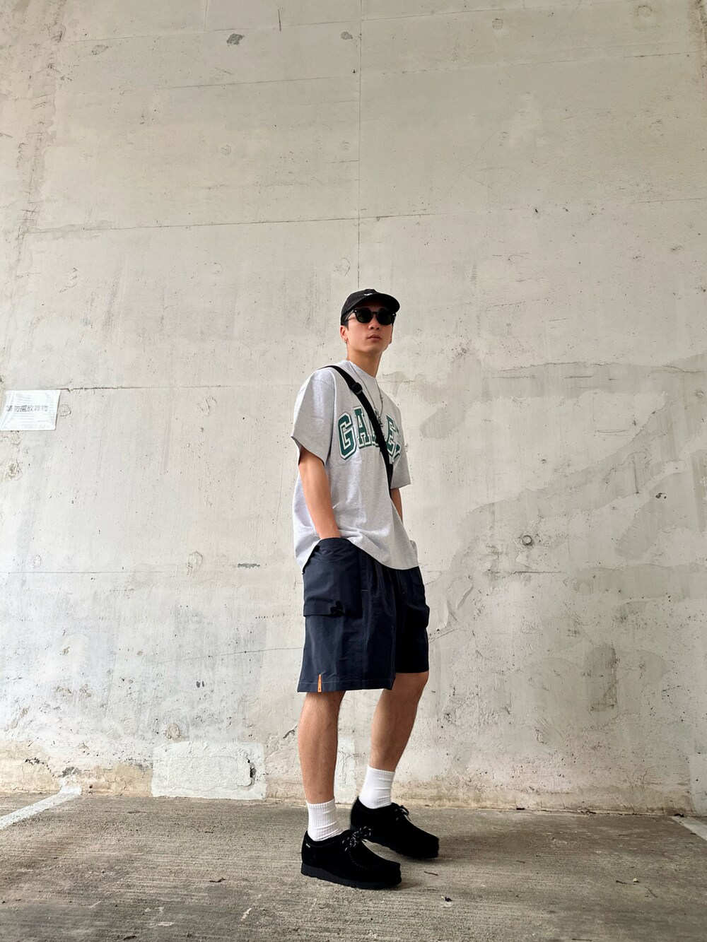 ブルー系のカーゴパンツ、グレー系のTシャツ/カットソー、ブラック系のシューズを着用したメンズの春コーディネートの2枚目の写真