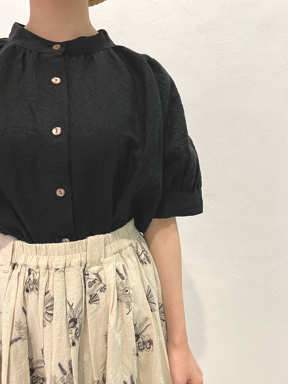 ブラック系のシャツ/ブラウス、ホワイト系のスカート、ブラック系のサンダルを着用したレディースの春コーディネートの3枚目の写真