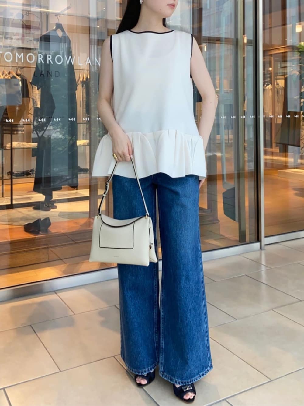 ブルー系のサンダル、ブルー系のデニムパンツ、ホワイト系のニット/セーターを着用したレディースの春コーディネートの4枚目の写真