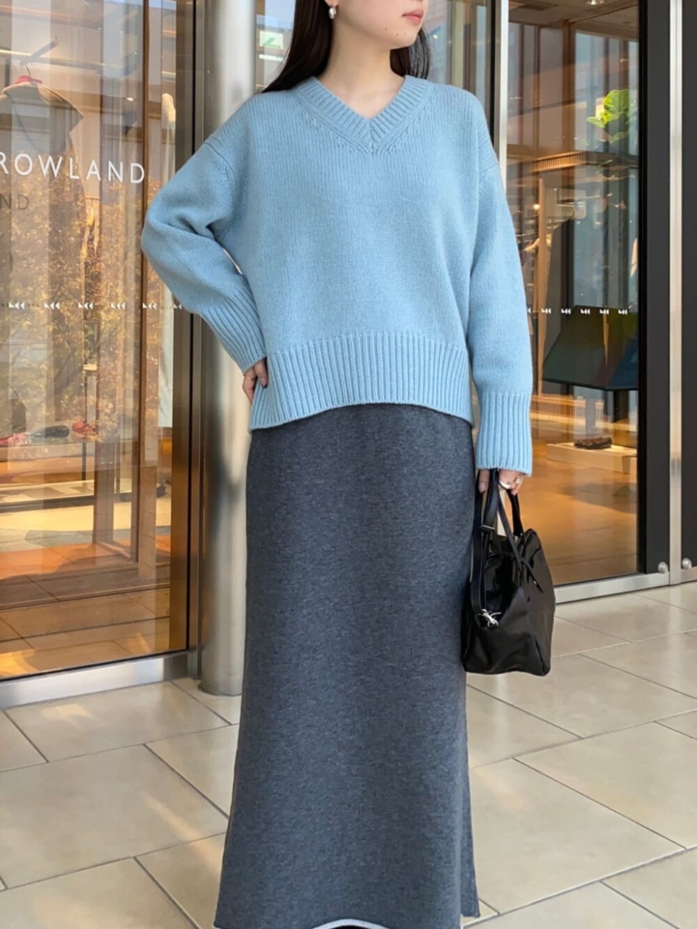 ブラック系のショルダーバッグ、ブラック系のブーツ、グレー系のスカートを着用したレディースの秋コーディネートの4枚目の写真