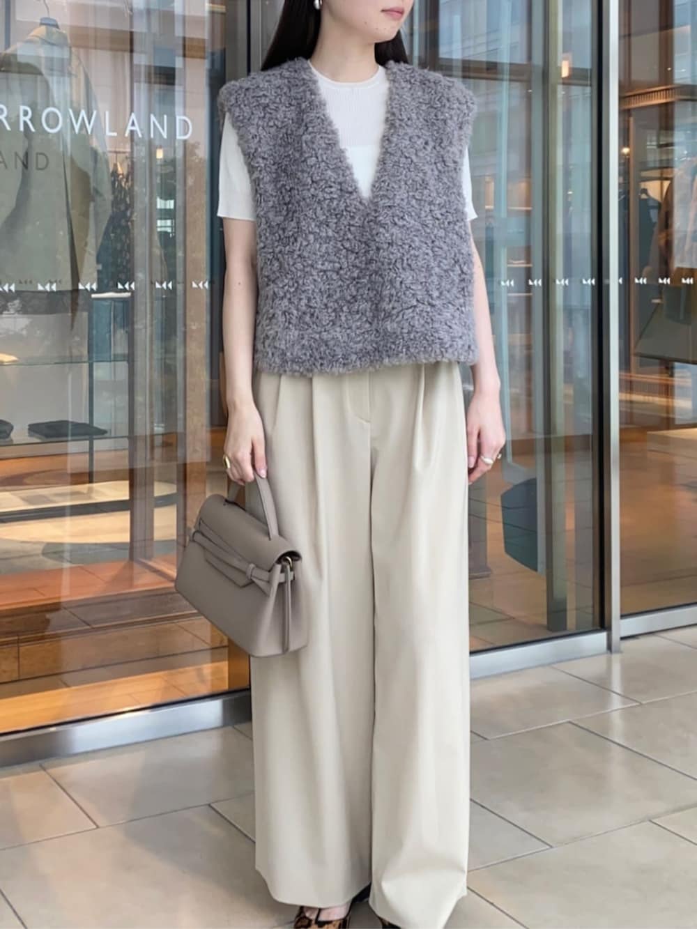 ホワイト系のニット/セーター、ベージュ系のその他パンツ、グレー系のベストを着用したレディースの夏コーディネートの3枚目の写真