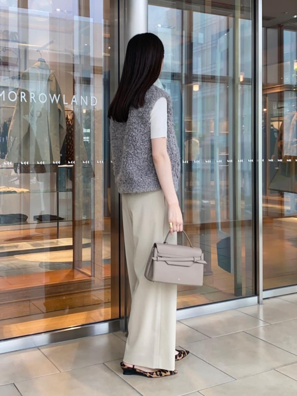 ホワイト系のニット/セーター、ベージュ系のその他パンツ、グレー系のベストを着用したレディースの夏コーディネートの2枚目の写真