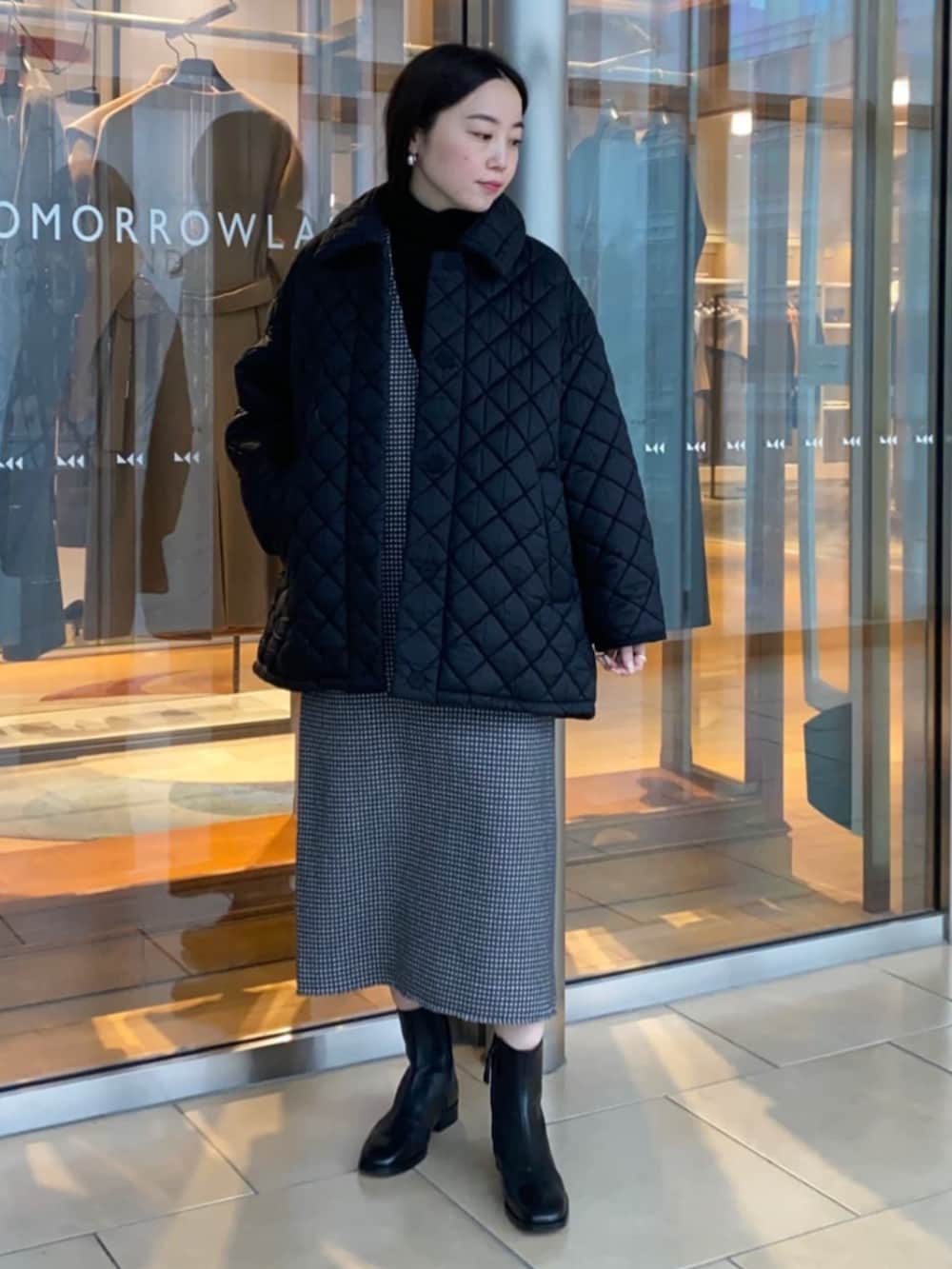 グレー系のワンピース、ブラック系のブーツ、ブラック系のその他アウターを着用したレディースの冬コーディネートの2枚目の写真