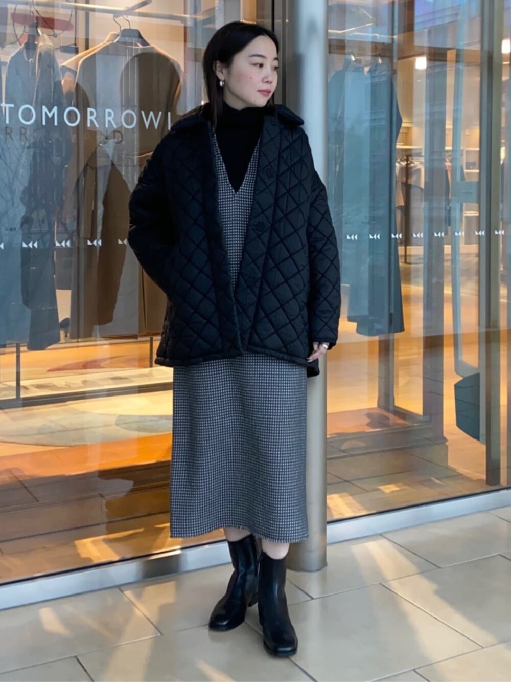 グレー系のワンピース、ブラック系のブーツ、ブラック系のその他アウターを着用したレディースの冬コーディネートの3枚目の写真