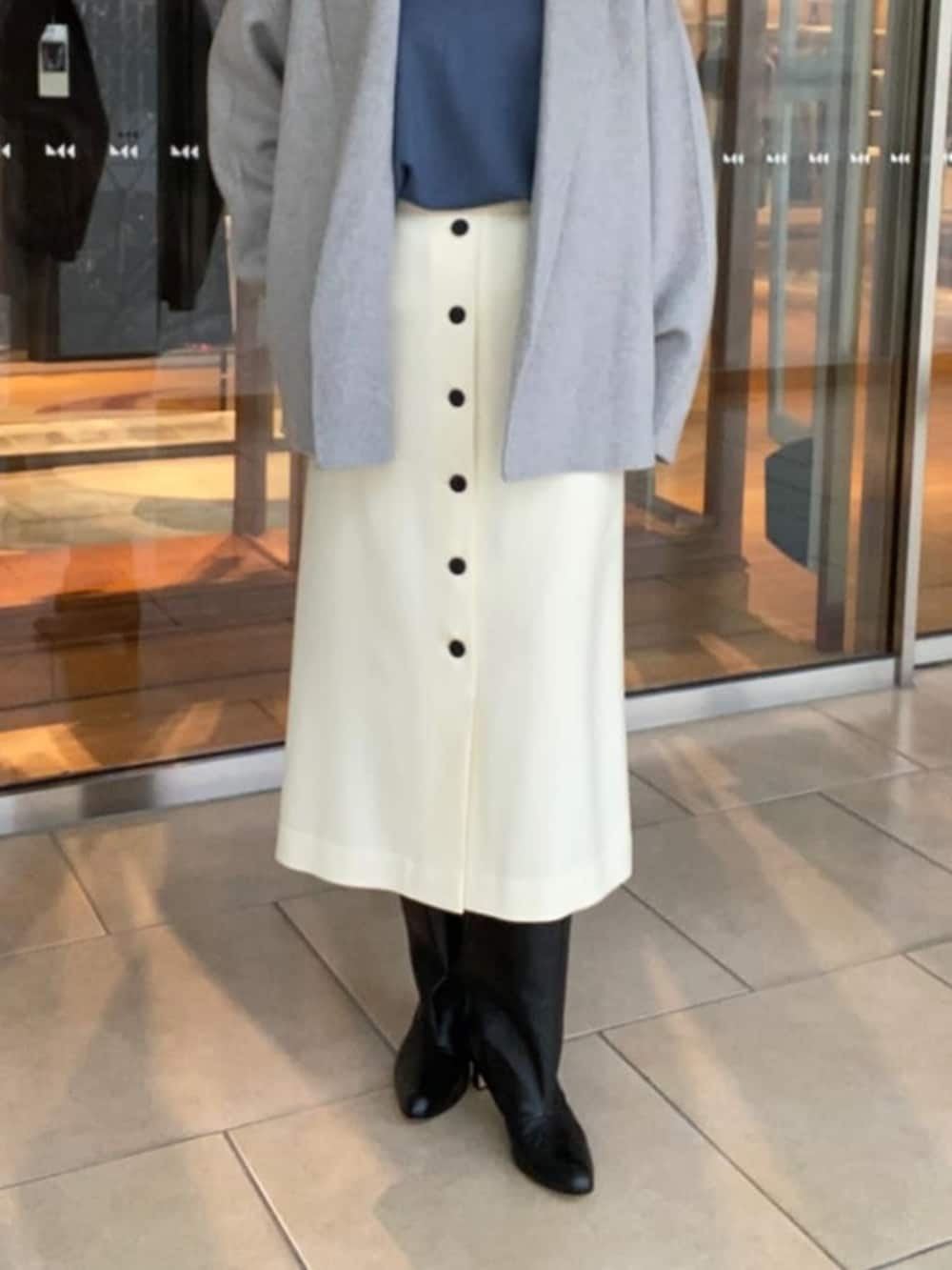 ブラック系のブーツ、グレー系のその他アウター、ブルー系のニット/セーターを着用したレディースの冬コーディネートの4枚目の写真