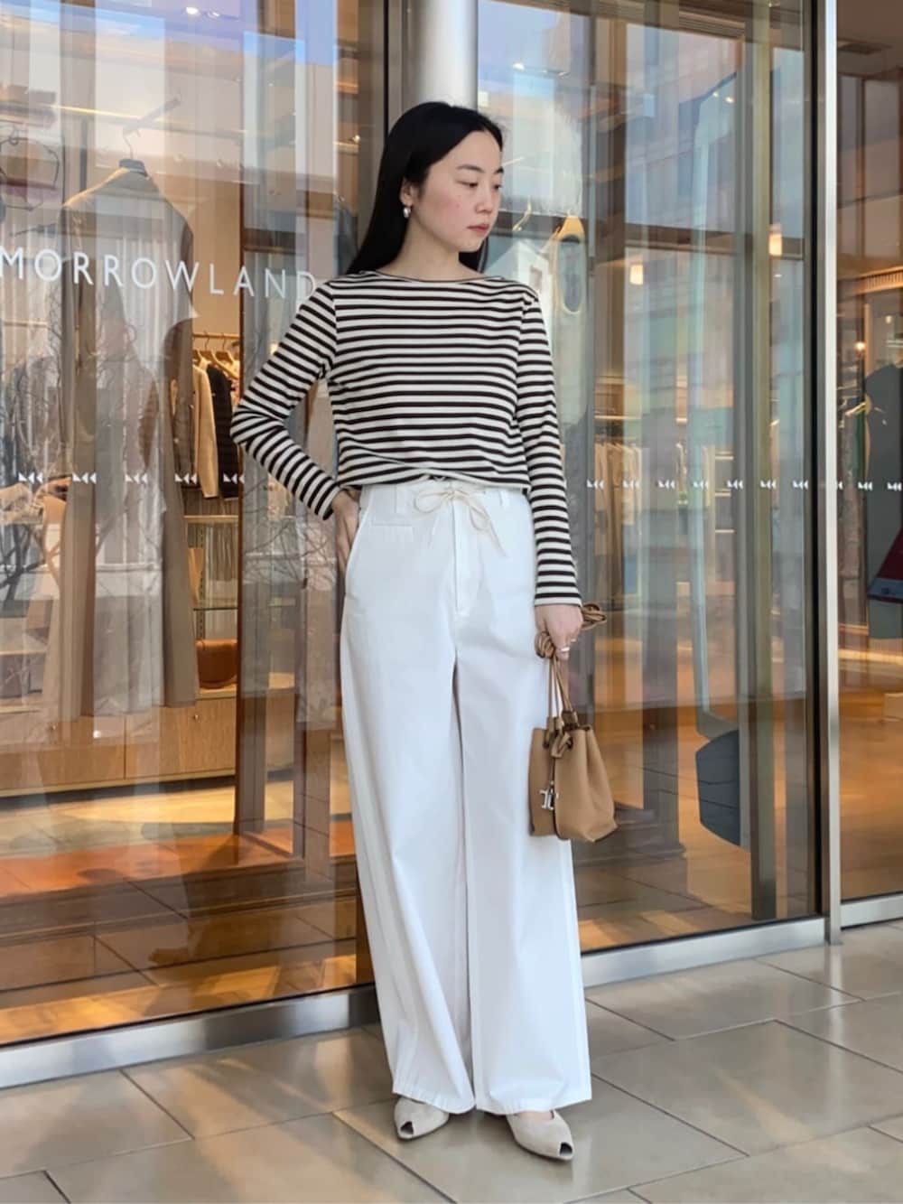 ホワイト系のその他パンツ、ベージュ系のその他アウター、ブラック系のTシャツ/カットソーを着用したレディースの春コーディネートの5枚目の写真