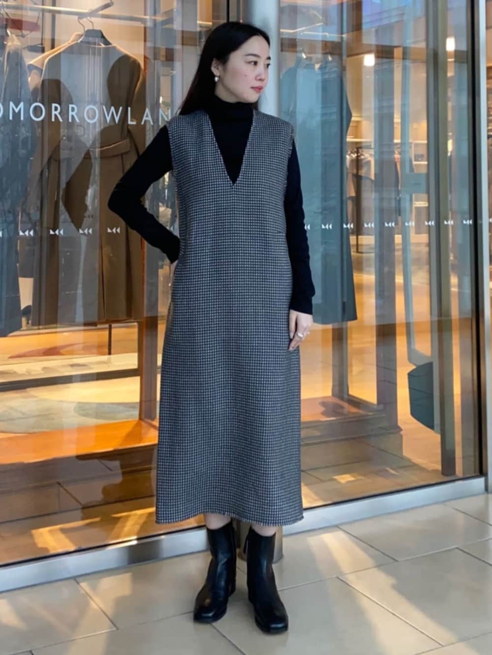 グレー系のワンピース、ブラック系のブーツ、ブラック系のその他アウターを着用したレディースの冬コーディネートの6枚目の写真