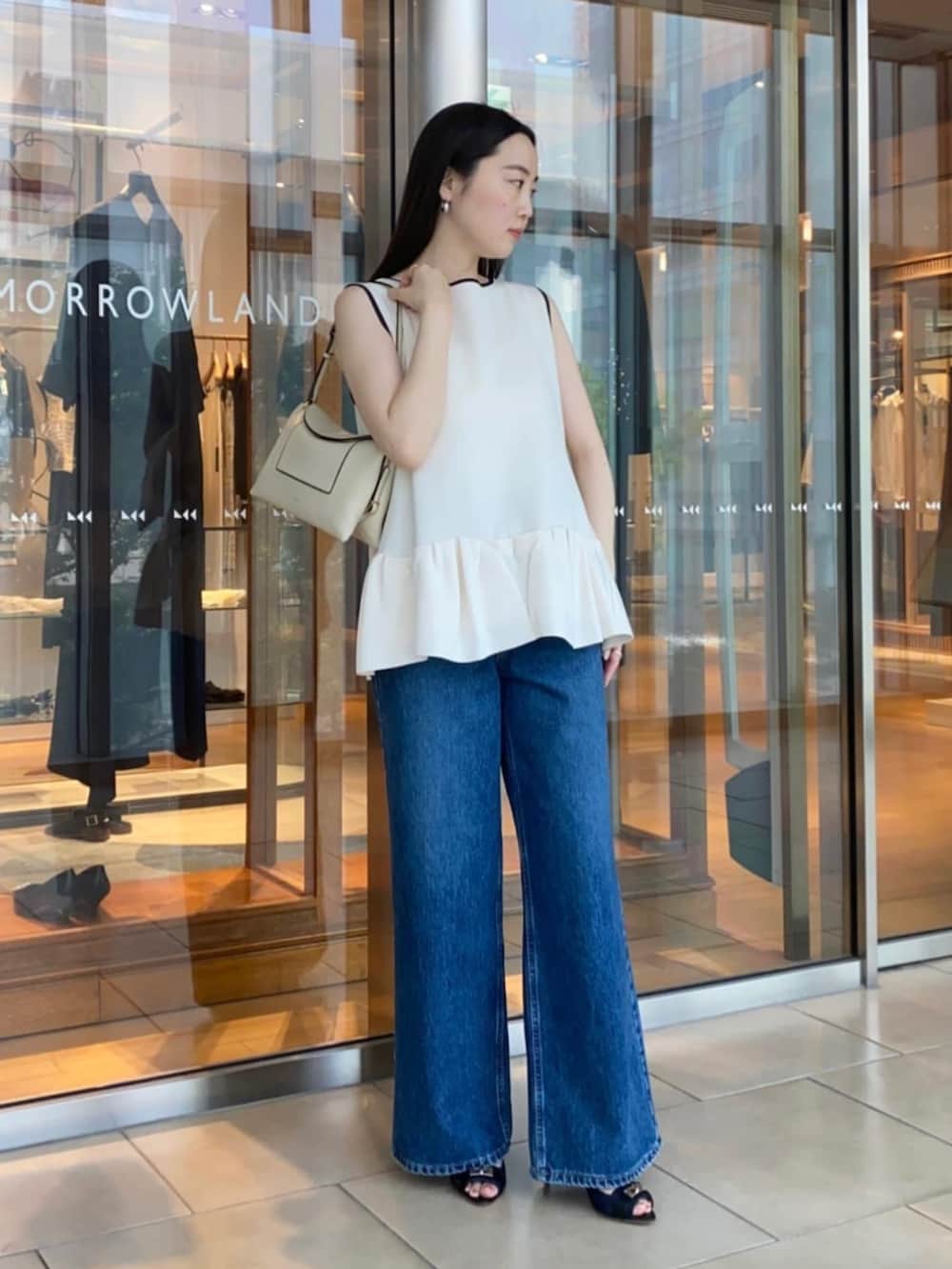 ブルー系のサンダル、ブルー系のデニムパンツ、ホワイト系のニット/セーターを着用したレディースの春コーディネートの3枚目の写真