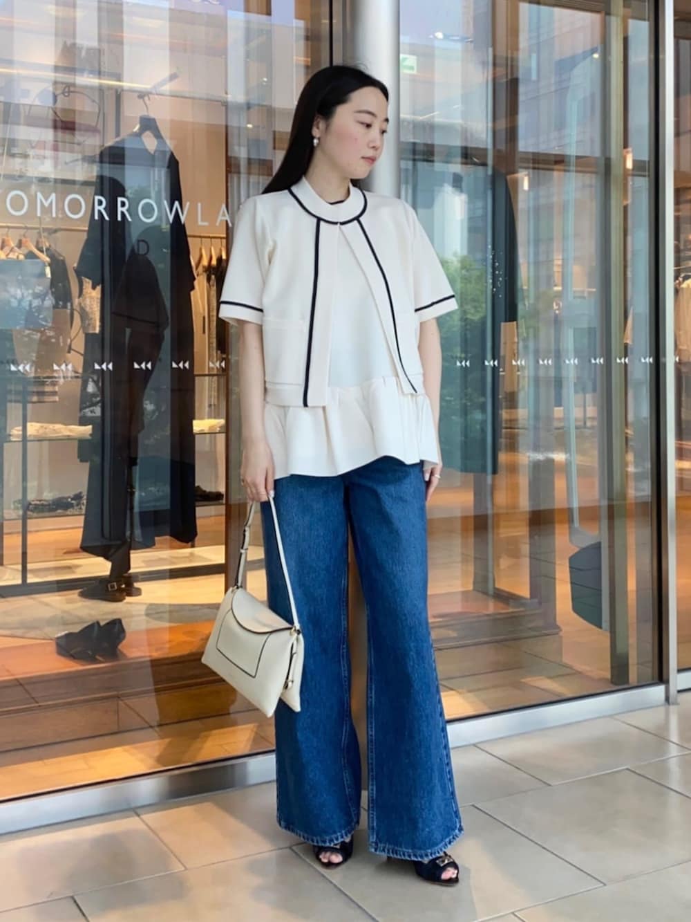 ブルー系のサンダル、ブルー系のデニムパンツ、ホワイト系のニット/セーターを着用したレディースの春コーディネートの2枚目の写真