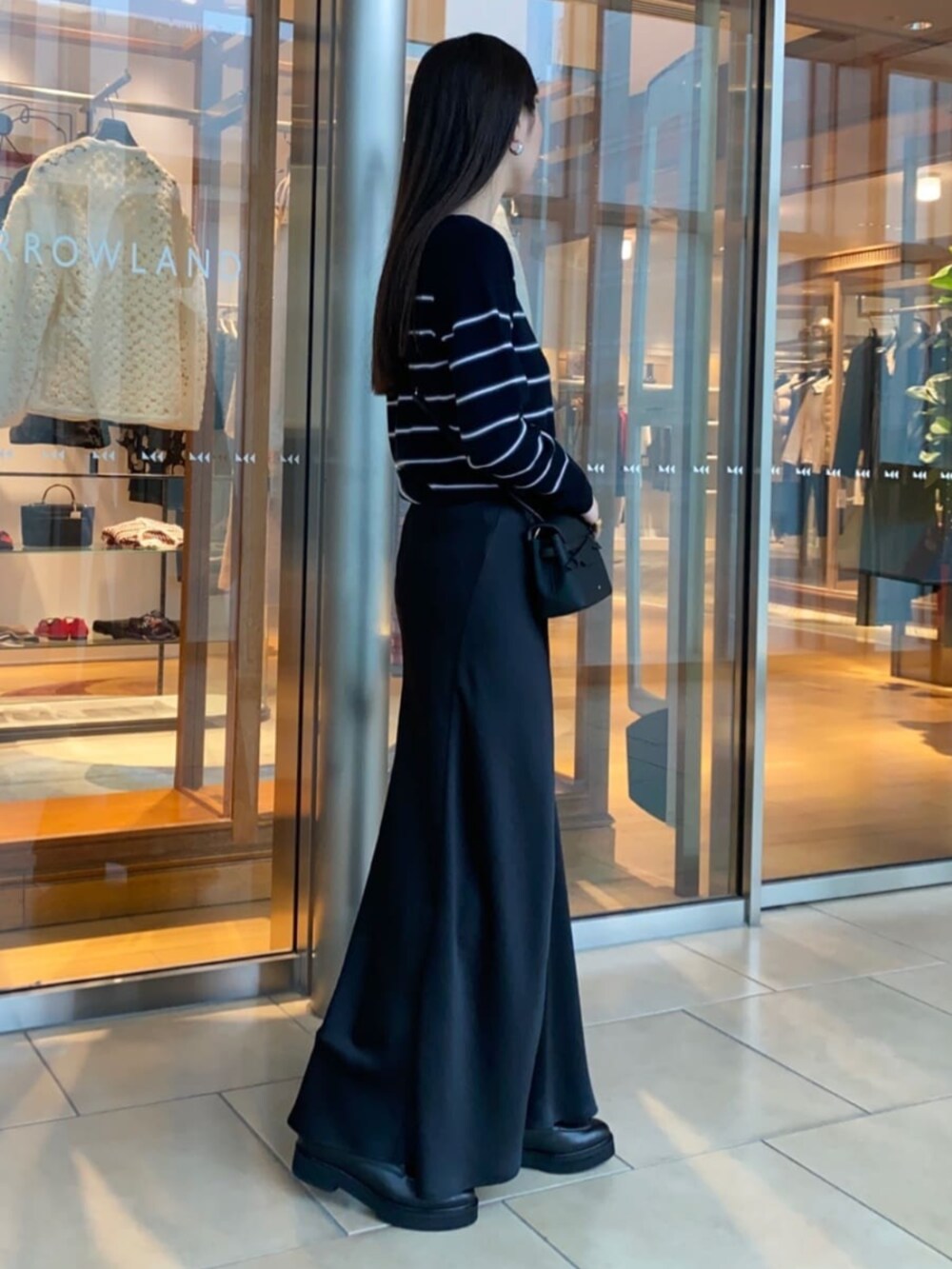 ブラック系のショルダーバッグ、ブラック系のブーツ、ブルー系のニット/セーターを着用したレディースの秋コーディネートの3枚目の写真