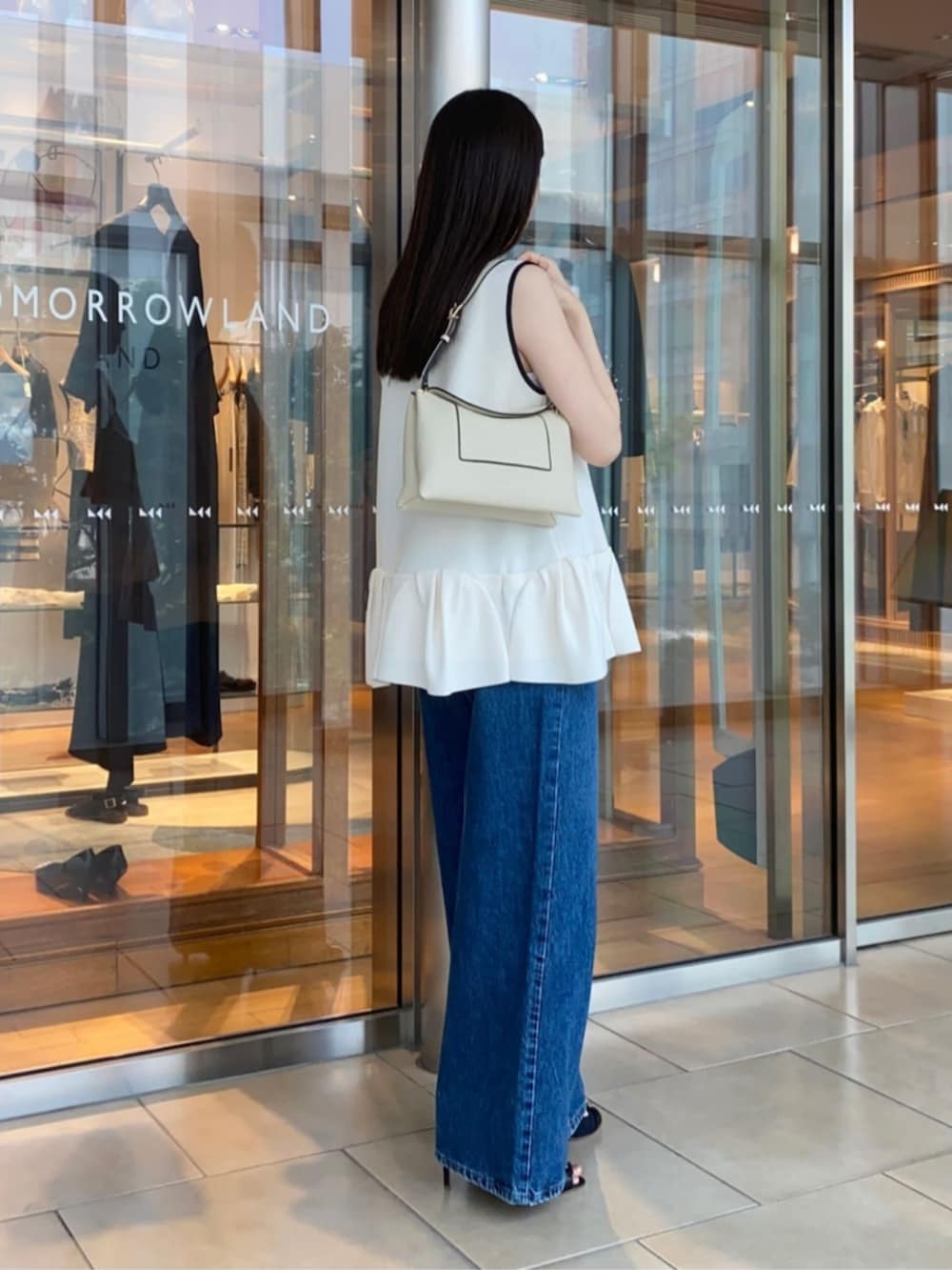 ブルー系のサンダル、ブルー系のデニムパンツ、ホワイト系のニット/セーターを着用したレディースの春コーディネートの5枚目の写真