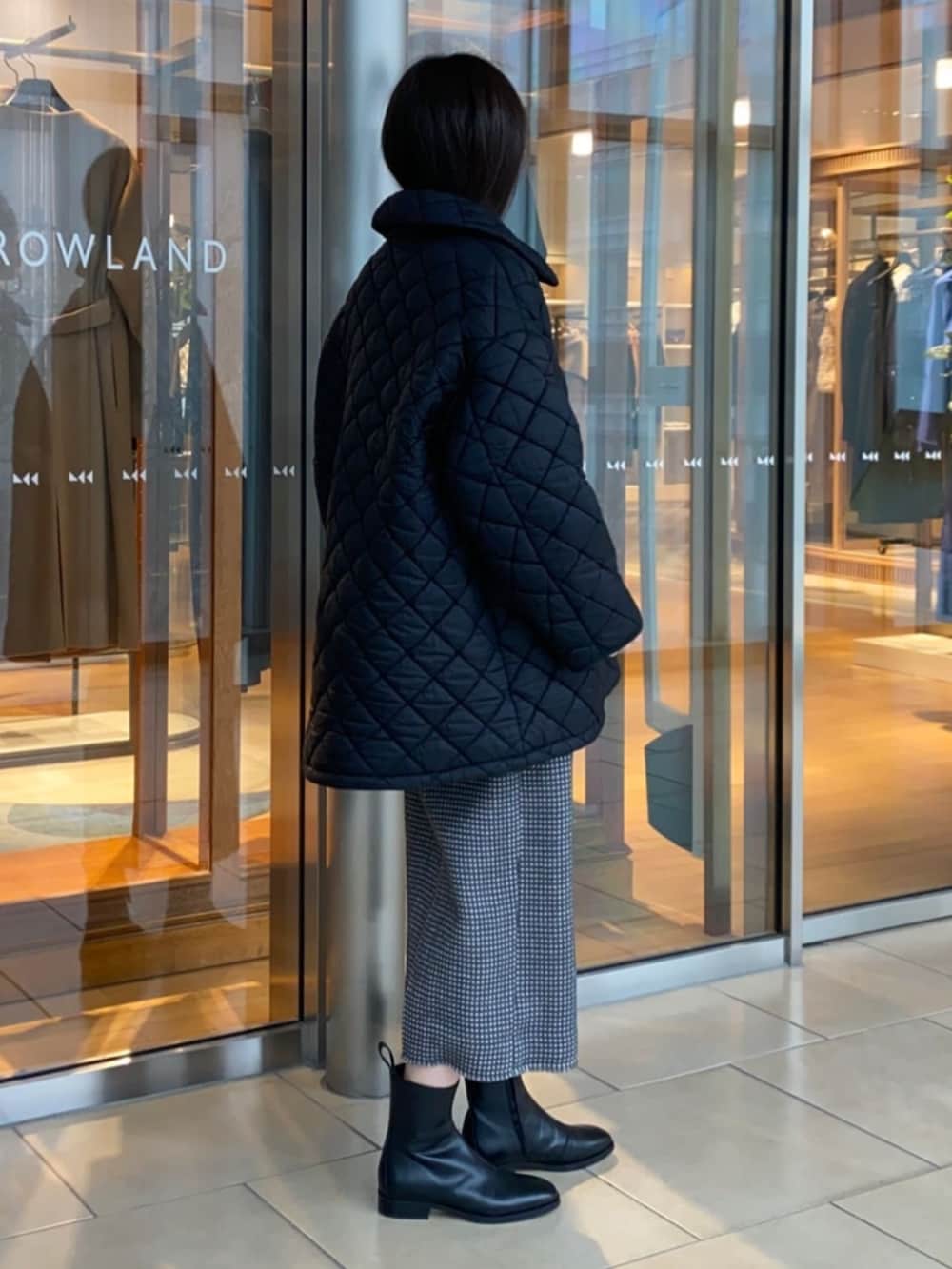 グレー系のワンピース、ブラック系のブーツ、ブラック系のその他アウターを着用したレディースの冬コーディネートの4枚目の写真