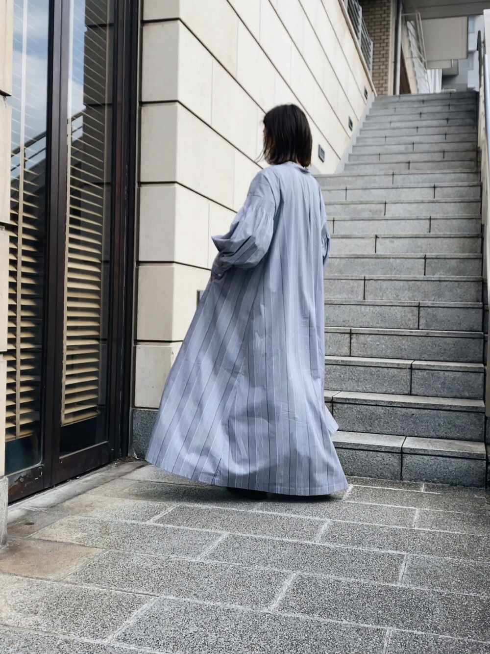 ブラック系のシャツワンピースを着用したレディースの春コーディネートの2枚目の写真