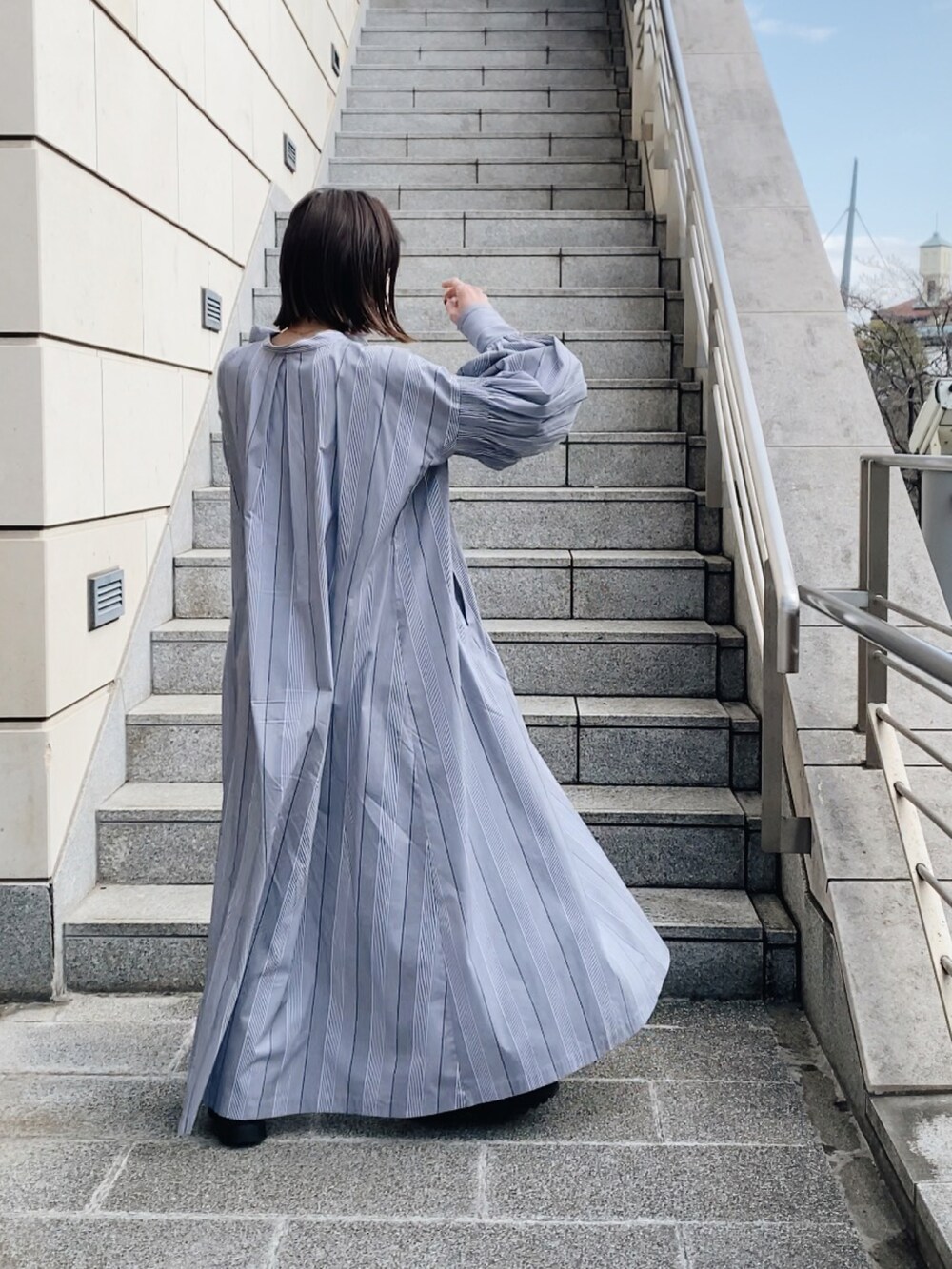 ブラック系のシャツワンピースを着用したレディースの春コーディネートの4枚目の写真