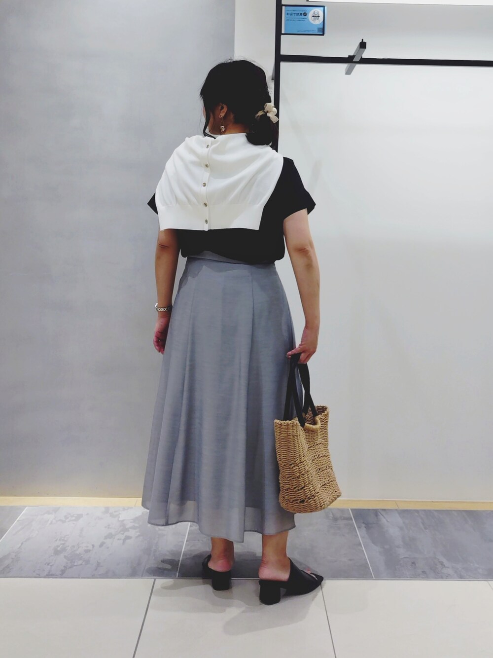 グレー系のスカート、ブラック系のシャツ/ブラウス、ベージュ系のトートバッグを着用したレディースの夏コーディネートの3枚目の写真