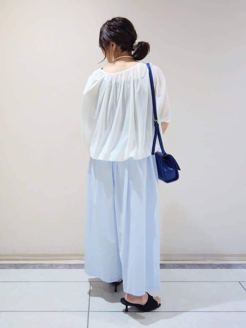 ブルー系のショルダーバッグ、ホワイト系のTシャツ/カットソー、グレー系のその他パンツを着用したレディースの春コーディネートの3枚目の写真