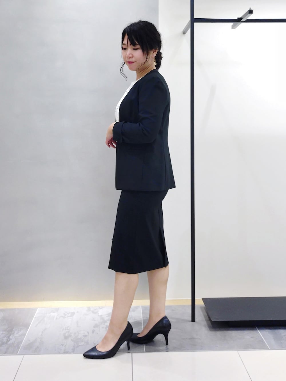 ホワイト系のシャツ/ブラウス、ブラック系のスーツジャケット、ブラック系のスーツスカートを着用したレディースの夏コーディネートの4枚目の写真