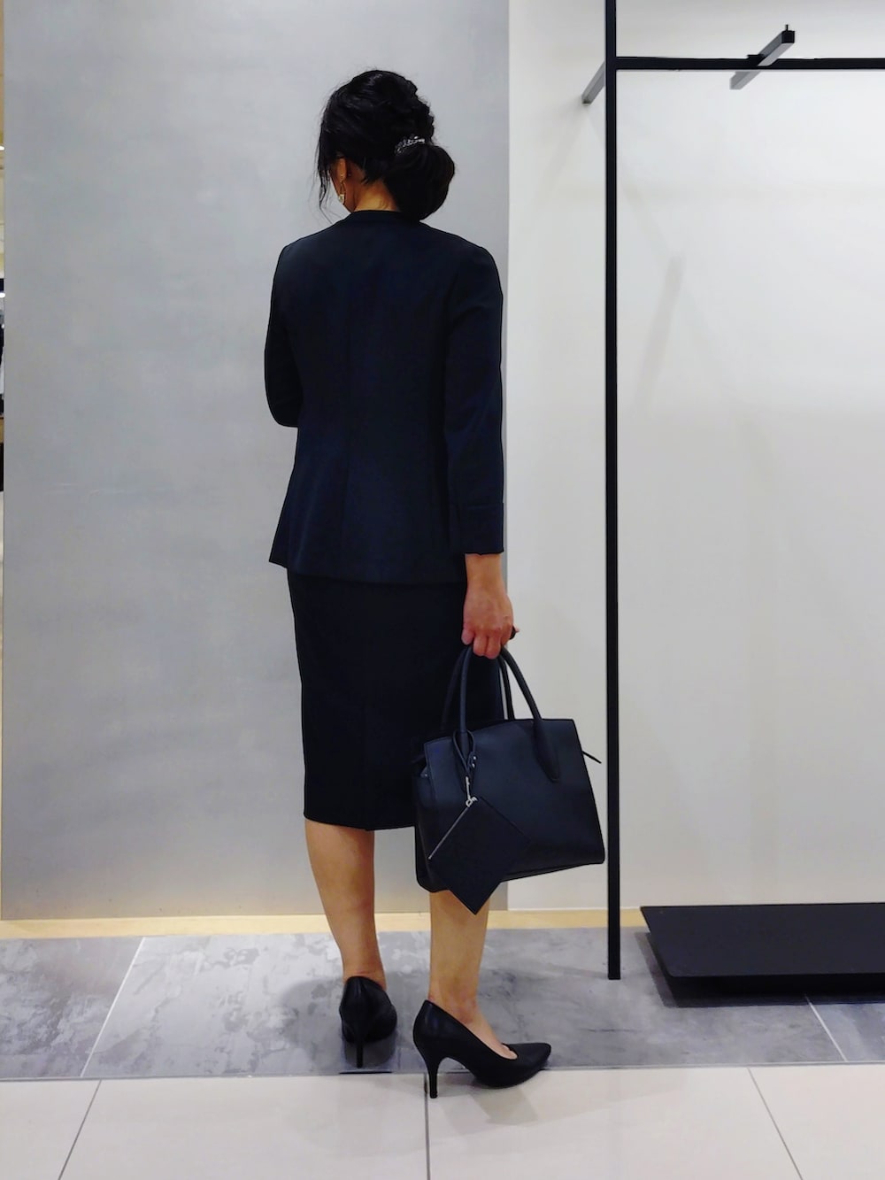 ホワイト系のシャツ/ブラウス、ブラック系のスーツジャケット、ブラック系のスーツスカートを着用したレディースの夏コーディネートの6枚目の写真
