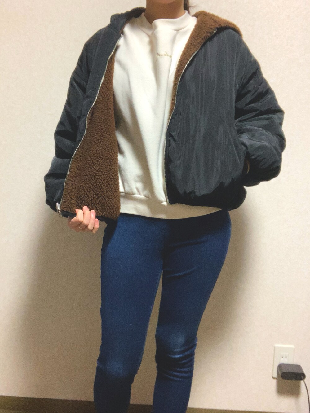 ブルー系のパンツ、ブラウン系のブルゾン、ホワイト系のTシャツ/カットソーを着用したレディースの冬コーディネートの2枚目の写真