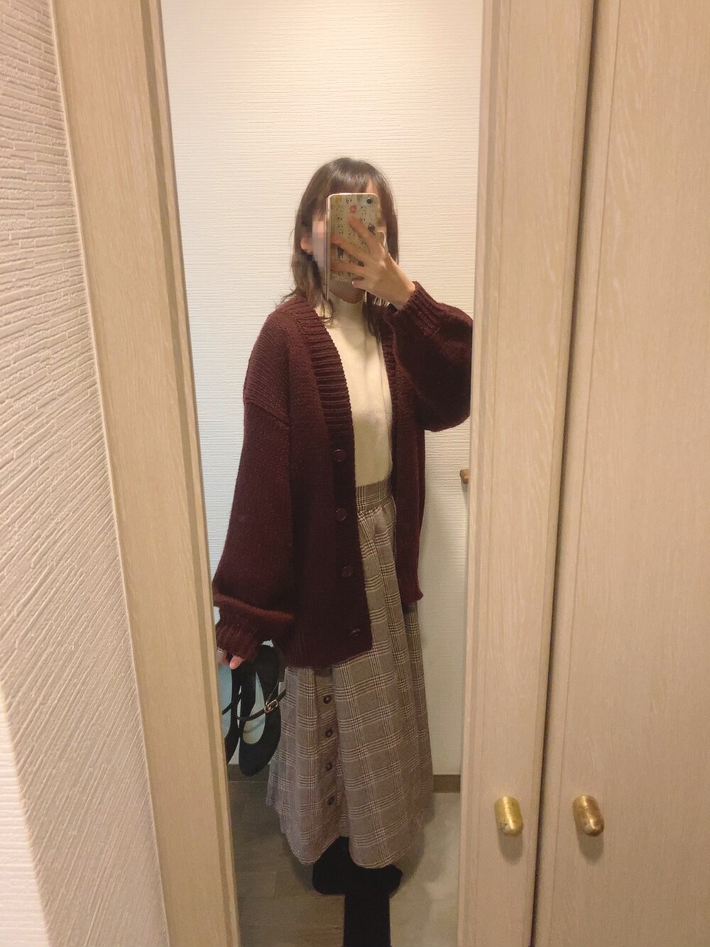 ブラウン系のスカート、ブラック系のパンプス、ホワイト系のニット/セーターを着用したレディースの冬コーディネートの2枚目の写真