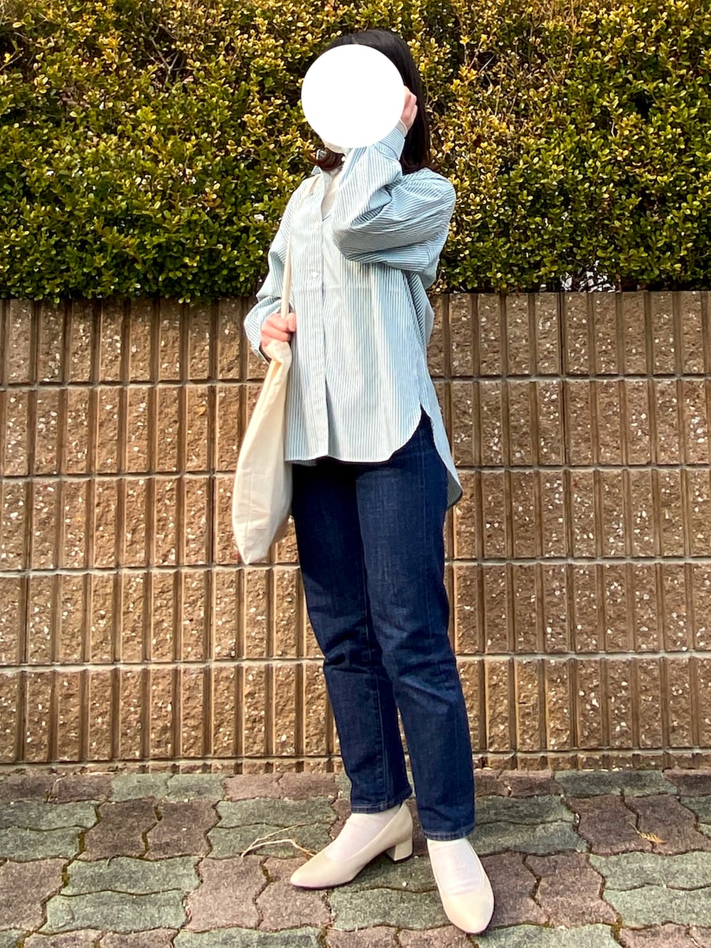 グリーン系のシャツ/ブラウス、ブルー系のデニムパンツ、ホワイト系のニット/セーターを着用したレディースの春コーディネートの2枚目の写真