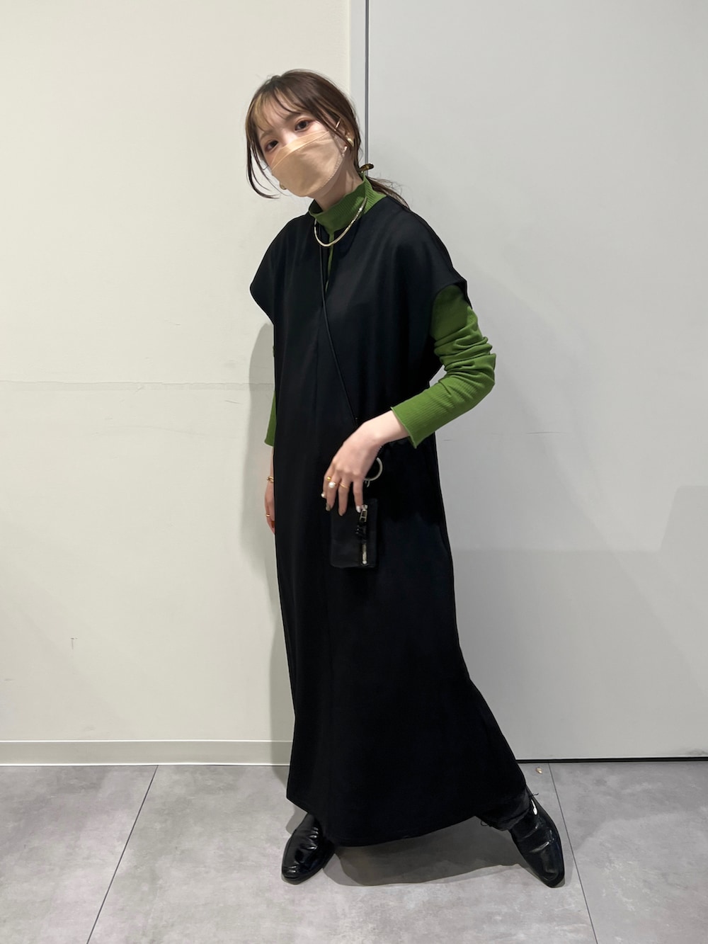 ブラック系のワンピース、グリーン系のTシャツ/カットソーを着用したレディースの冬コーディネートの3枚目の写真