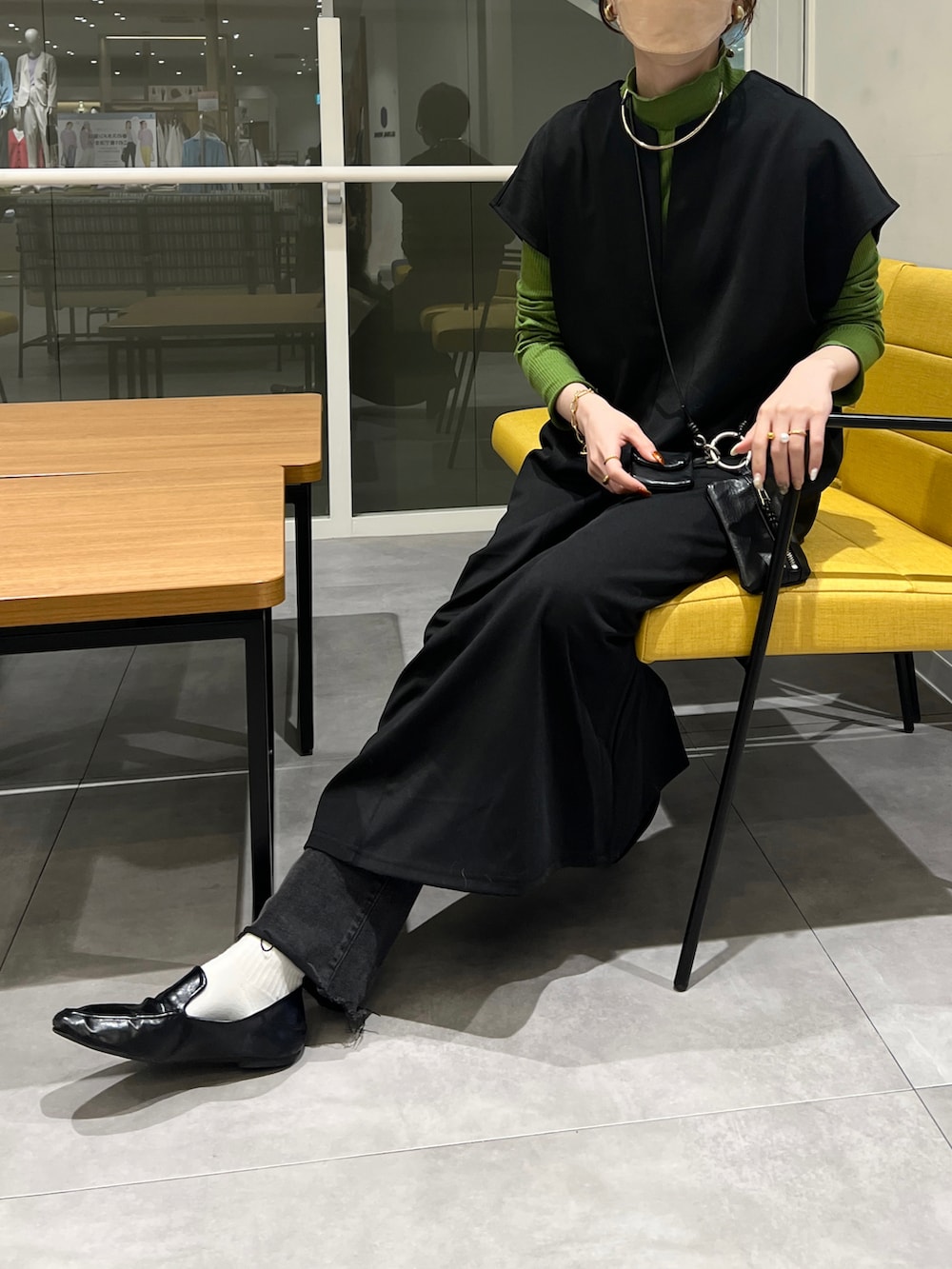 ブラック系のワンピース、グリーン系のTシャツ/カットソーを着用したレディースの冬コーディネートの2枚目の写真