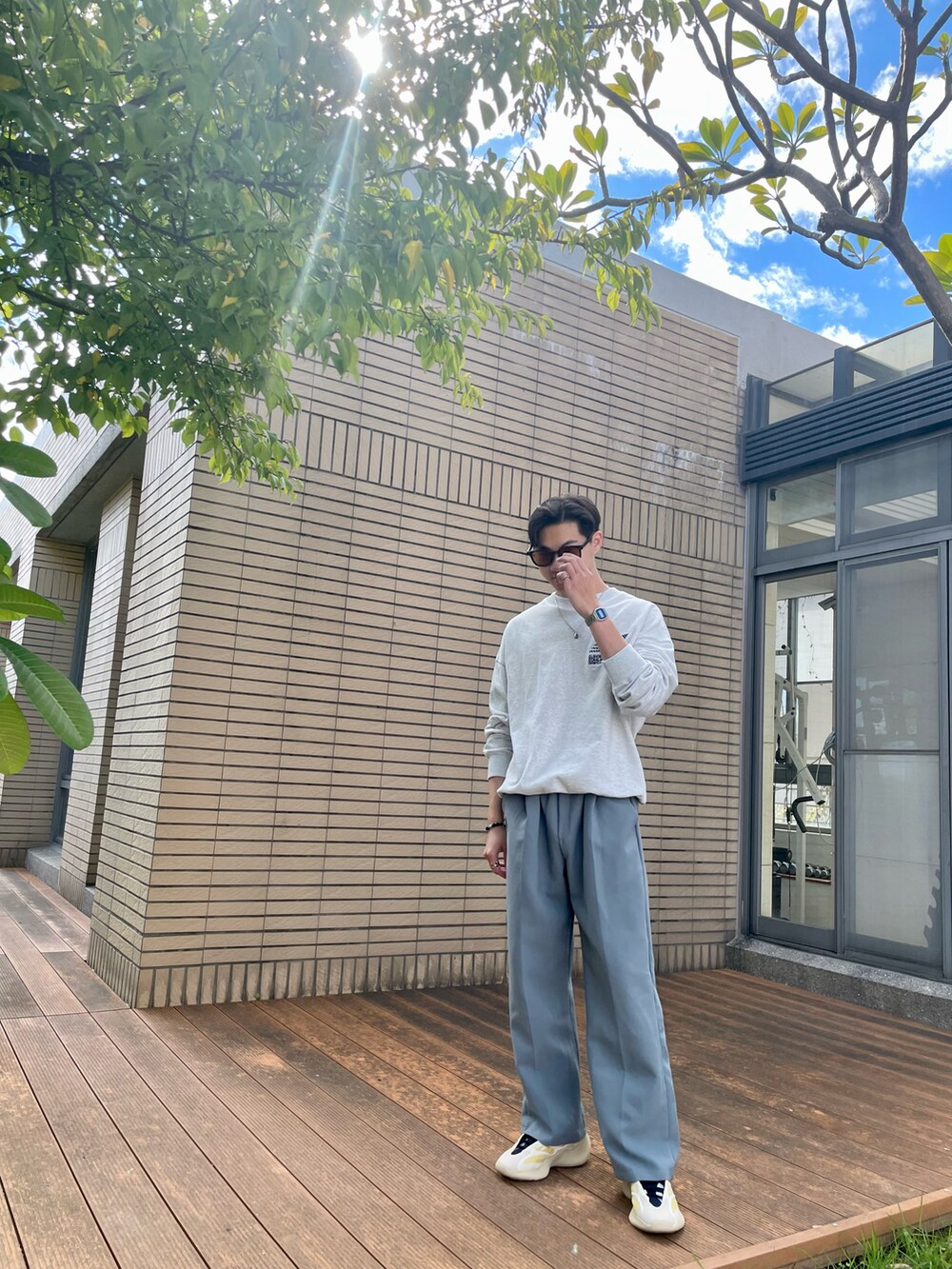 グレー系のスウェット、グリーン系のチノパンツを着用したメンズの冬コーディネートの3枚目の写真