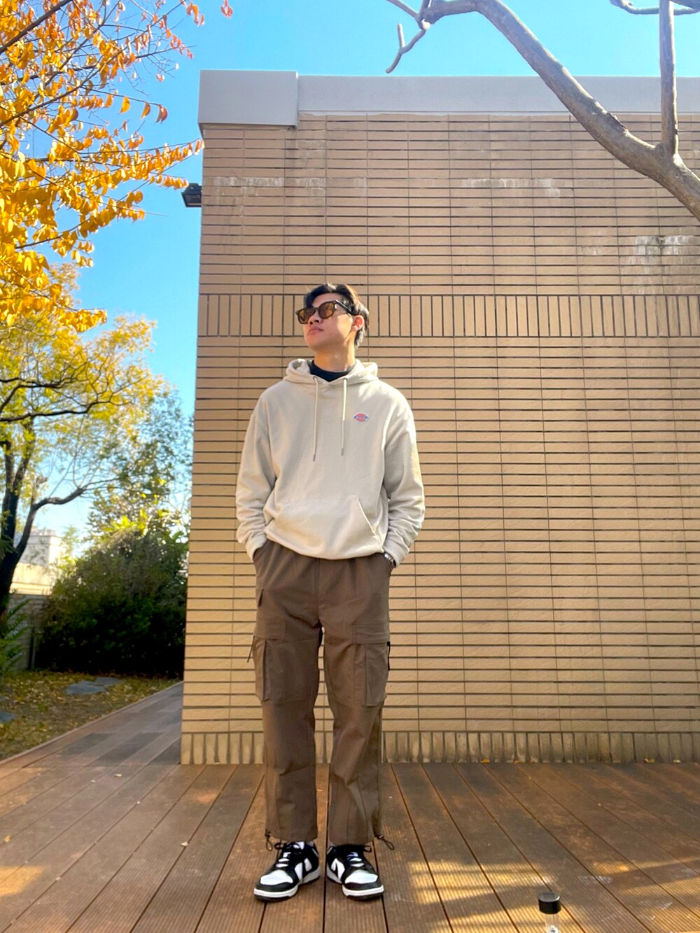 ベージュ系のスウェット、ブラック系のスニーカーを着用したメンズの冬コーディネートの3枚目の写真