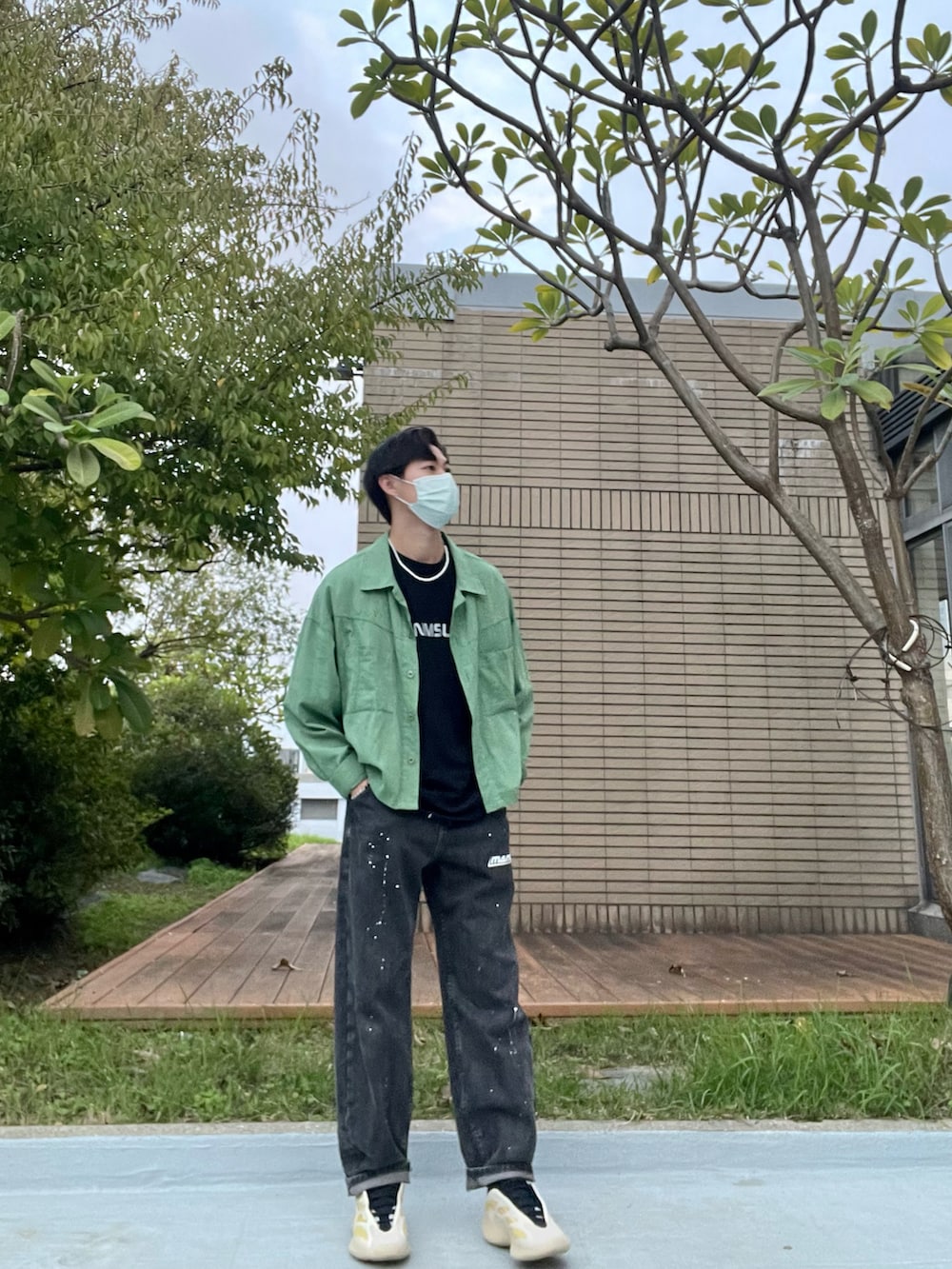 ブラック系のデニムパンツ、ブラック系のTシャツ/カットソー、グリーン系のブルゾンを着用したメンズの秋コーディネートの3枚目の写真