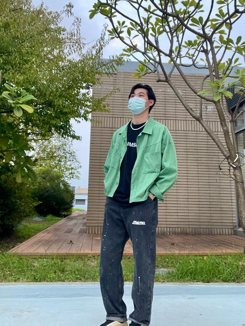 ブラック系のデニムパンツ、ブラック系のTシャツ/カットソー、グリーン系のブルゾンを着用したメンズの秋コーディネートの5枚目の写真