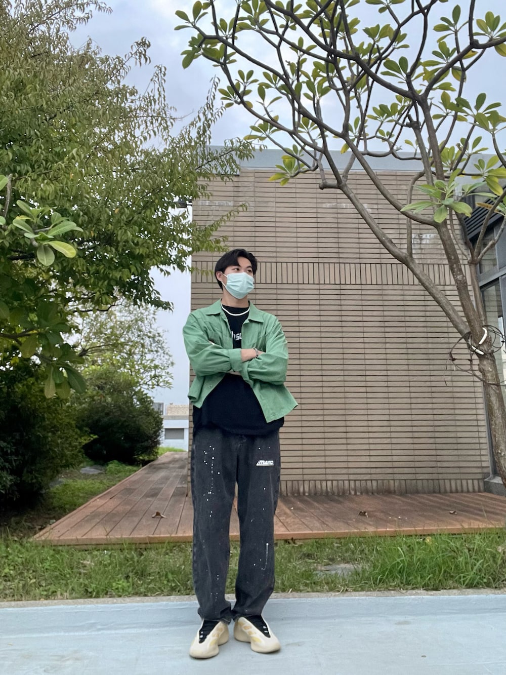 ブラック系のデニムパンツ、ブラック系のTシャツ/カットソー、グリーン系のブルゾンを着用したメンズの秋コーディネートの2枚目の写真