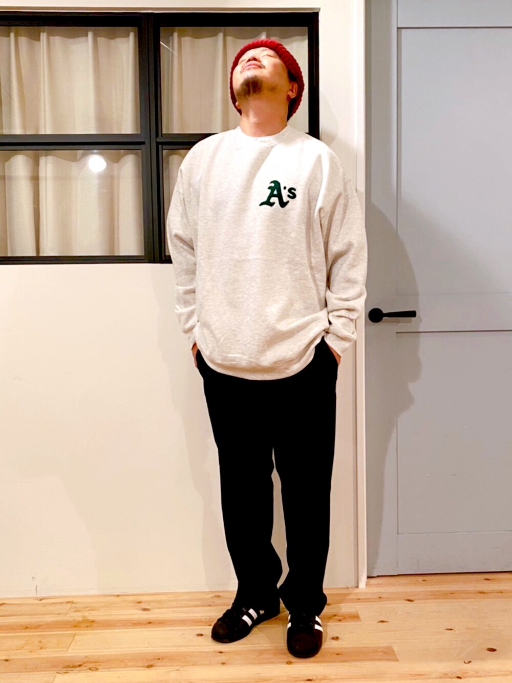 ブラック系のチノパンツ、ホワイト系のスウェット、レッド系のニットキャップ/ビーニーを着用したメンズの冬コーディネートの2枚目の写真