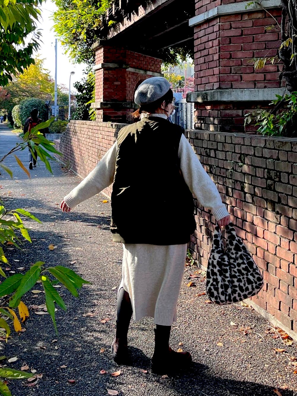 ベージュ系のワンピース、グレー系のスウェット、ベージュ系のトートバッグを着用したレディースの秋コーディネートの2枚目の写真