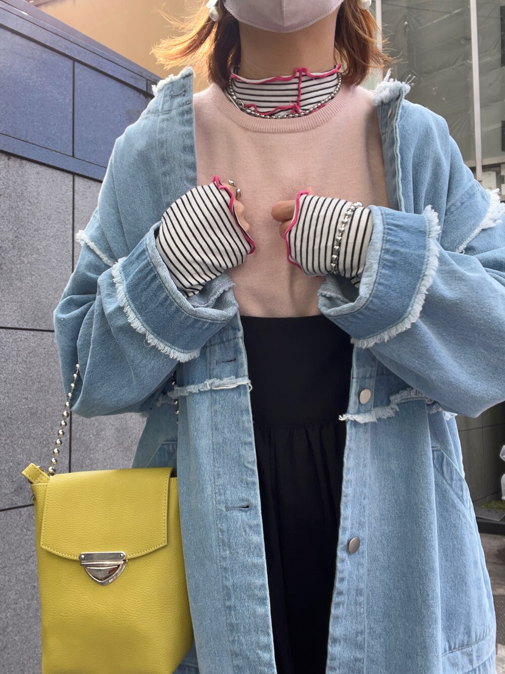 ブルー系のデニムジャケット、ピンク系のニット/セーター、ブラック系のサロペット/オーバーオールを着用したレディースの春コーディネートの2枚目の写真