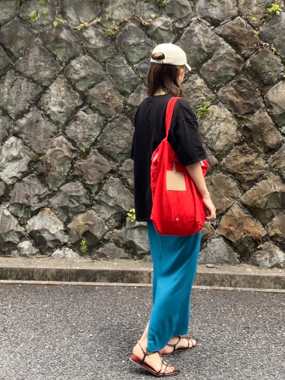 ブラック系のTシャツ/カットソー、ブラック系のバッグ、ブラウン系のサンダルを着用したレディースの夏コーディネートの3枚目の写真