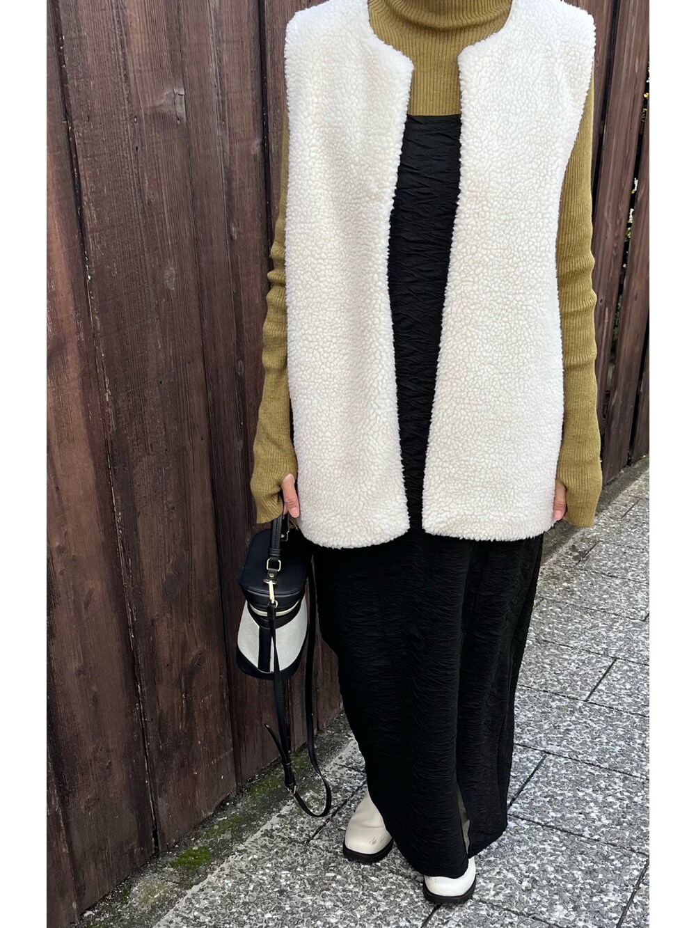 ブラック系のワンピース、グリーン系のニット/セーター、ホワイト系のブーツを着用したレディースの秋コーディネートの3枚目の写真