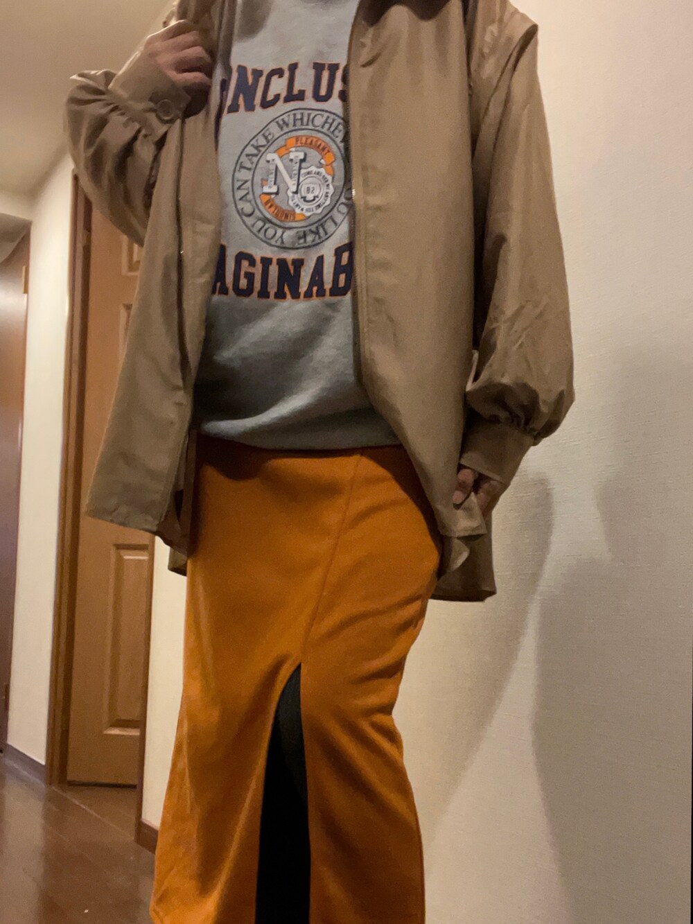 グレー系のスウェット、ブラック系のスカート、ブラック系のトートバッグを着用したレディースの秋コーディネートの2枚目の写真